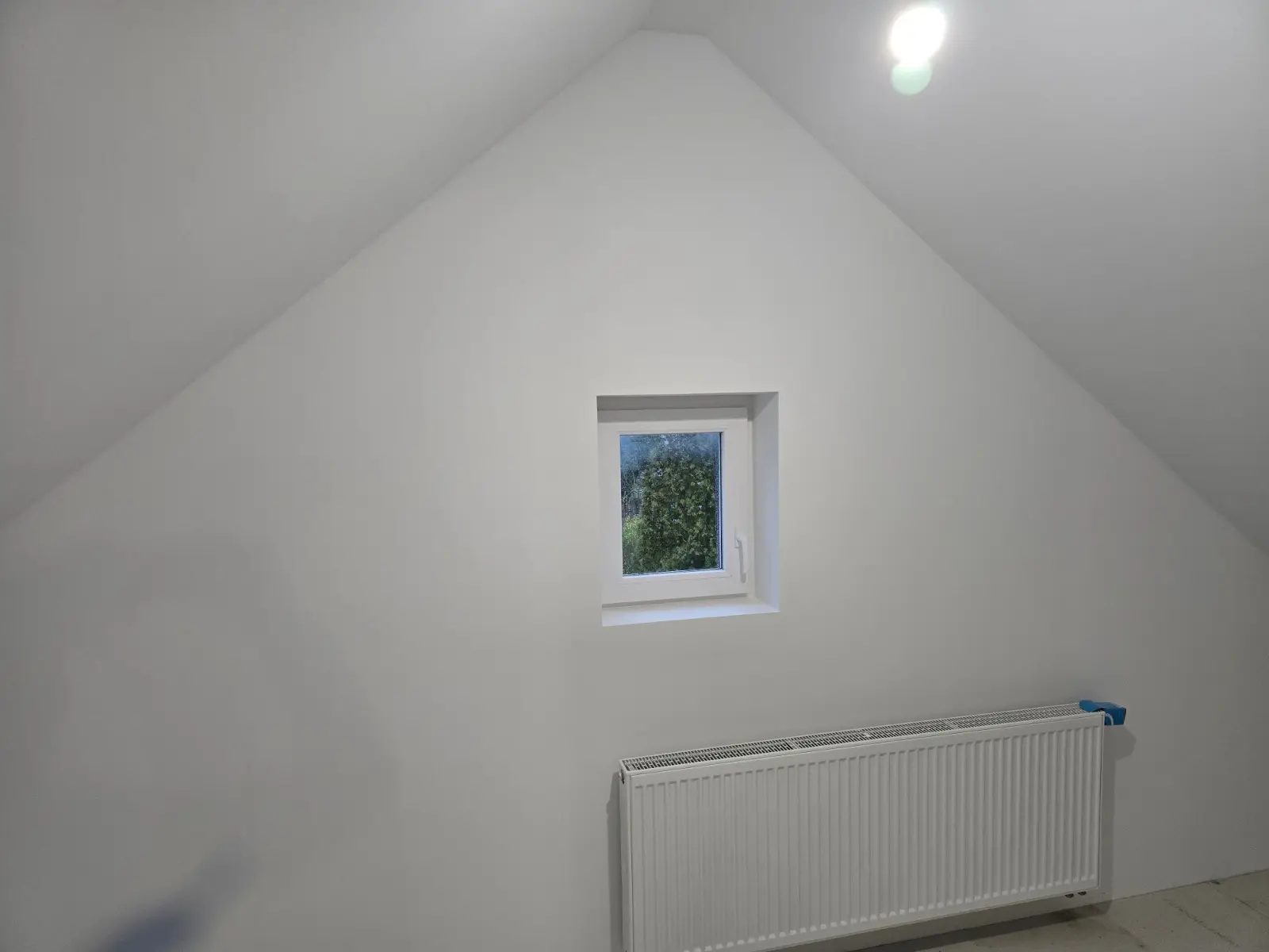 Fertiges Giebelzimmer mit Fenster und Heizkörper