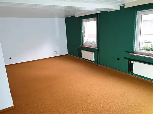 Raum mit grüner Akzentwand und neuem Teppichboden